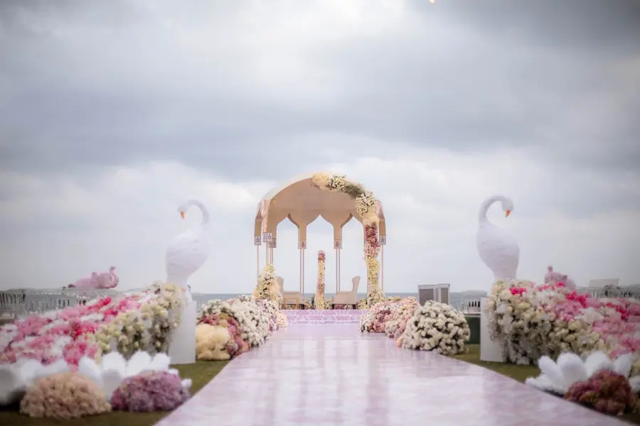 Gilded ceremony gazebo framed against a dramatic sky over the sea